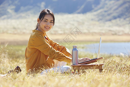 在草地上工作的女人图片
