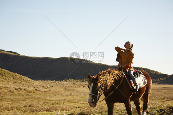 草原上骑马旅游的女人图片