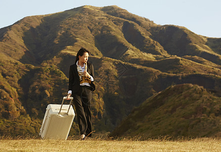 草原上的带着行李箱的酷女孩图片