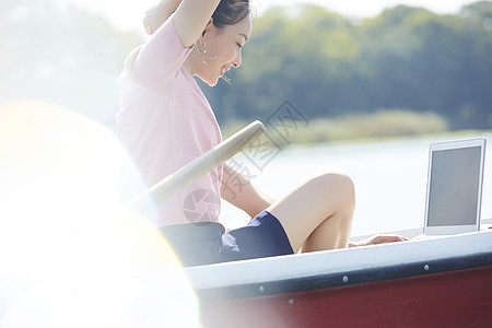 湖泊船上独自旅行的女人用电脑图片