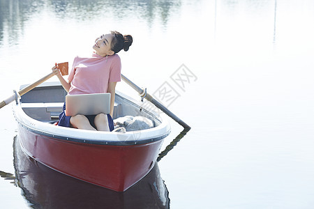 湖泊船上独自旅行的女人用电脑图片