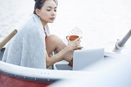 湖泊船上独自旅行的女人用电脑图片