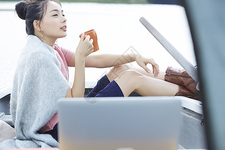 湖泊船上独自旅行的女人用电脑图片