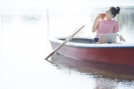 湖泊船上的女孩用笔记本电脑图片