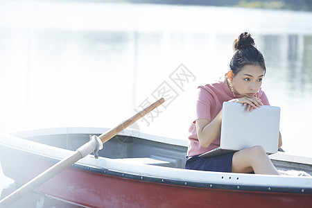 湖泊船上的女孩用笔记本电脑图片