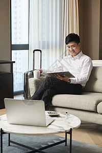 商务男青年出差在酒店工作图片素材