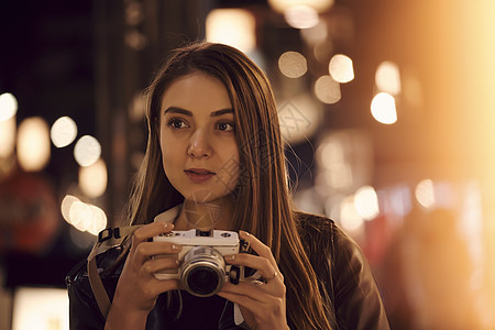 夜晚街头手拿相机的女生图片