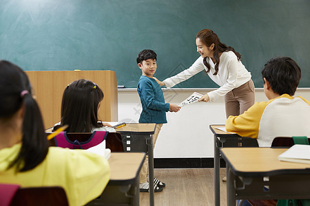 小学生上台接过老师给的纸张图片