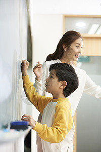 小学生在黑板上写字图片