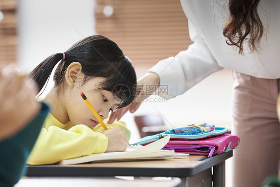 老师在检查小学生的作业图片