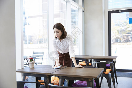 成年女子拿着抹布擦桌子图片