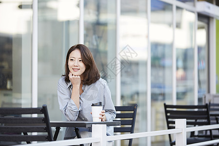 户外咖啡馆休息喝咖啡的年轻女子背景图片