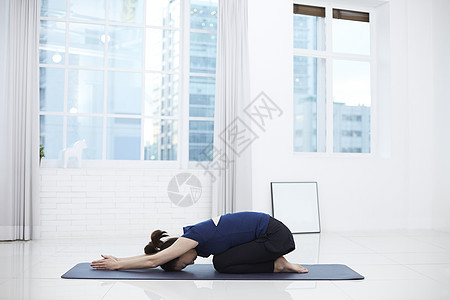瑜伽垫上做瑜伽的女性图片