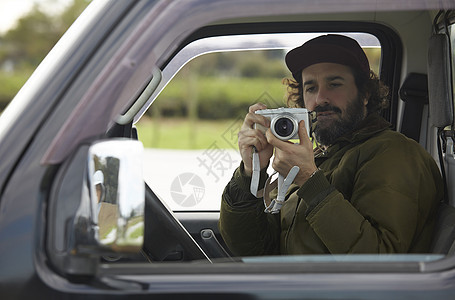 年轻人相机拍摄外国人驾驶一辆卡车图片