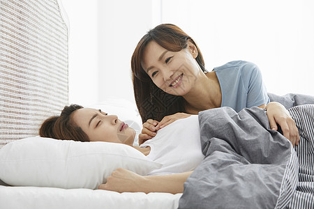 gre考试床上妈妈关心看着睡着的女儿背景