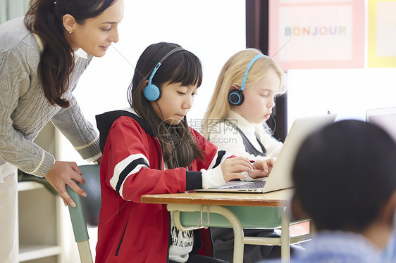 老师指导小学生上国际学校在线课程图片