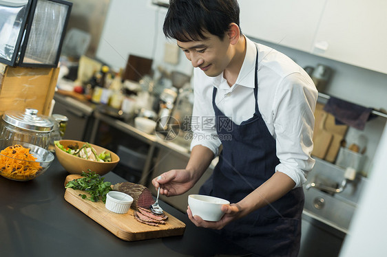 厨房内制作料理的厨师图片