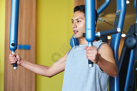 健身房锻炼器械的运动男人图片