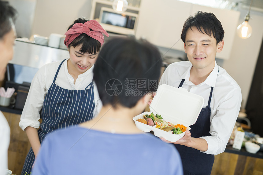 碟壮年男人卖午餐盒食物事务的已婚夫妇图片