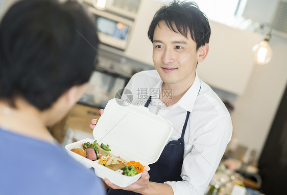 餐馆里做好午餐给顾客的男子图片