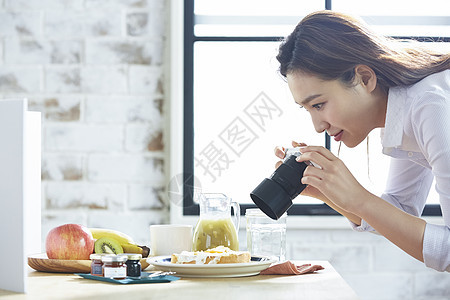 自制早餐拍照的职业女性图片