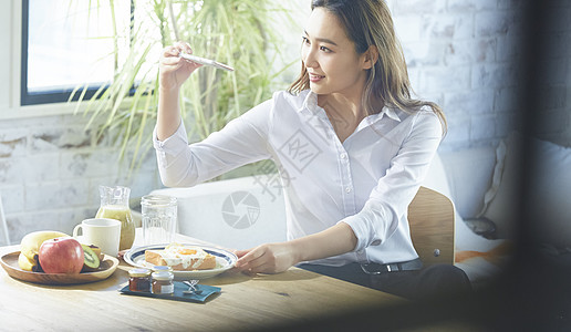 自制早餐拍照的职业女性图片