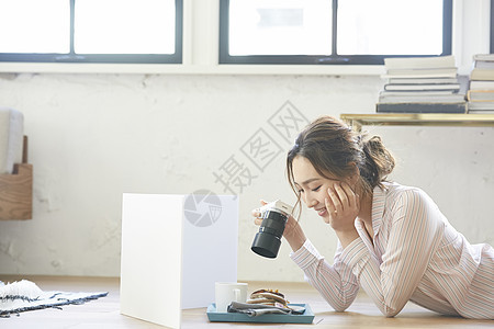 趴在地上拿着相机的女青年图片