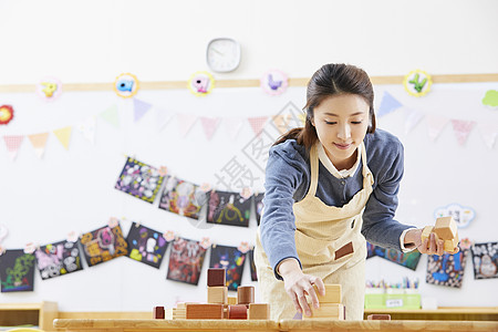 幼儿园的老师在带着学生们画画图片