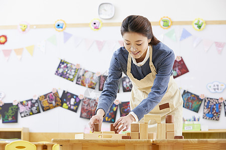 幼儿园的老师在带着学生们画画图片