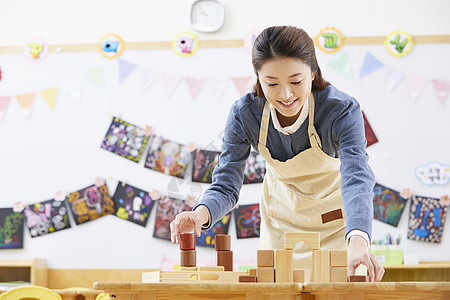 幼儿园的老师在带着学生们画画图片