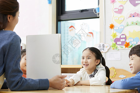 幼儿园的老师在带着学生们画画图片