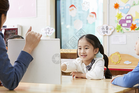 幼儿园的老师在带着学生们画画图片