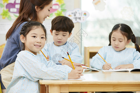 幼儿园的老师在带着学生们画画图片