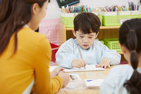 幼儿园的老师在带着学生们画画图片