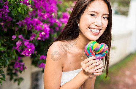 拿着彩色面包微笑的年轻女子图片