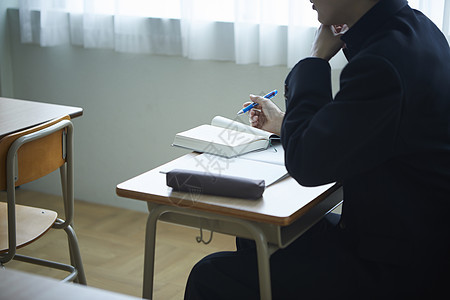 课桌上学习的学生特写图片