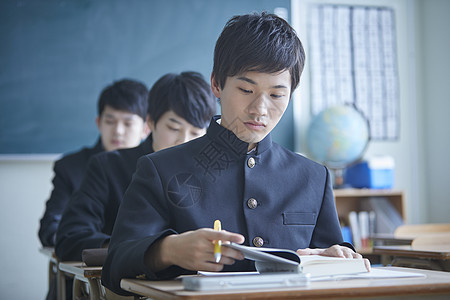 日式制服的男学生在教室里学习图片