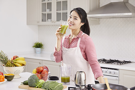 厨房里喝着果蔬汁的年轻女子图片