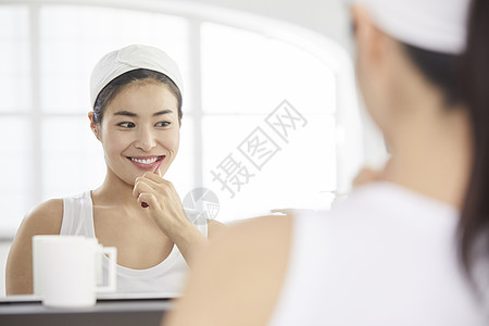 镜子前刷牙洗漱的青年女子图片