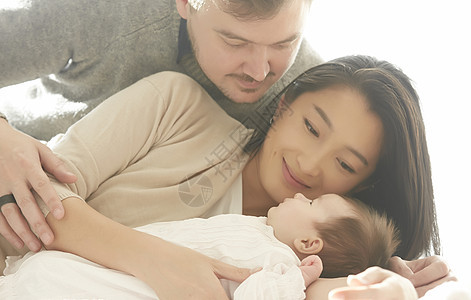 抱着婴儿幸福的三口之家图片