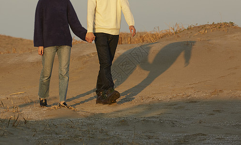 一对夫妇沿着海岸散步图片