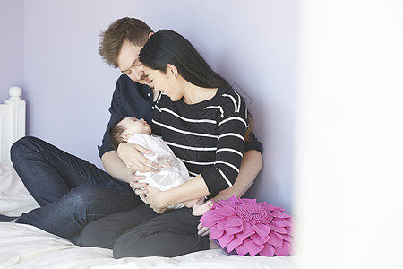 在卧室照顾婴儿的夫妇图片素材