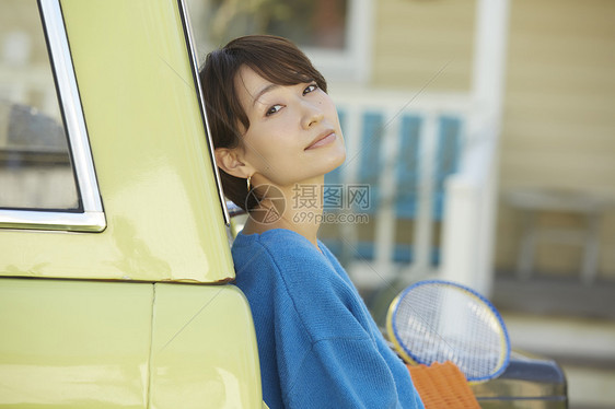 汽车旁边的年轻女子图片