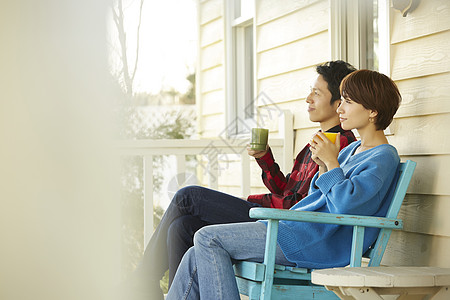 房屋外喝茶的青年情侣图片
