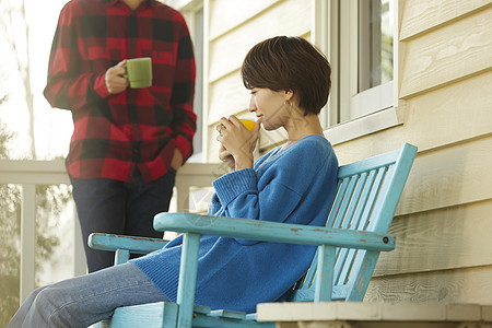 房屋外喝茶的年轻夫妻图片