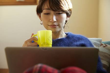 客厅喝咖啡看电脑的女人图片