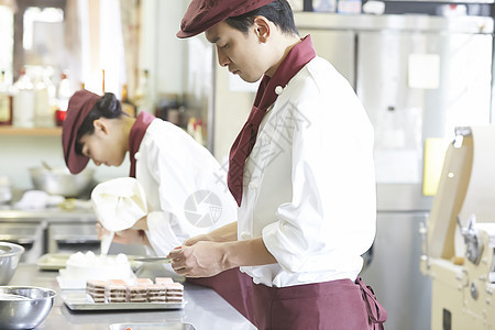 碟男人们女生工作在蛋糕店的男人和妇女图片