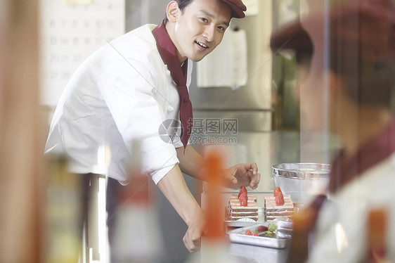 甜品青年微笑在蛋糕店工作的人图片