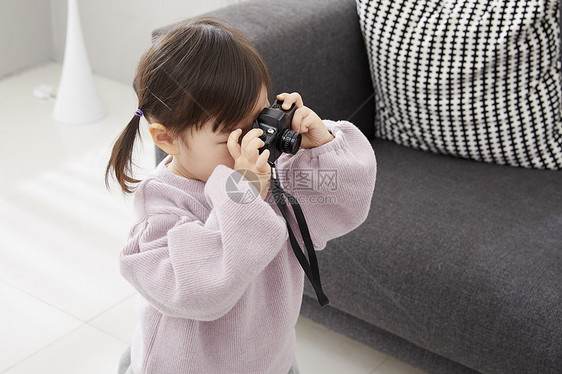 住房生活的女孩用相机拍照图片