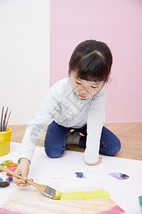 拿着刷子涂鸦的小女孩图片